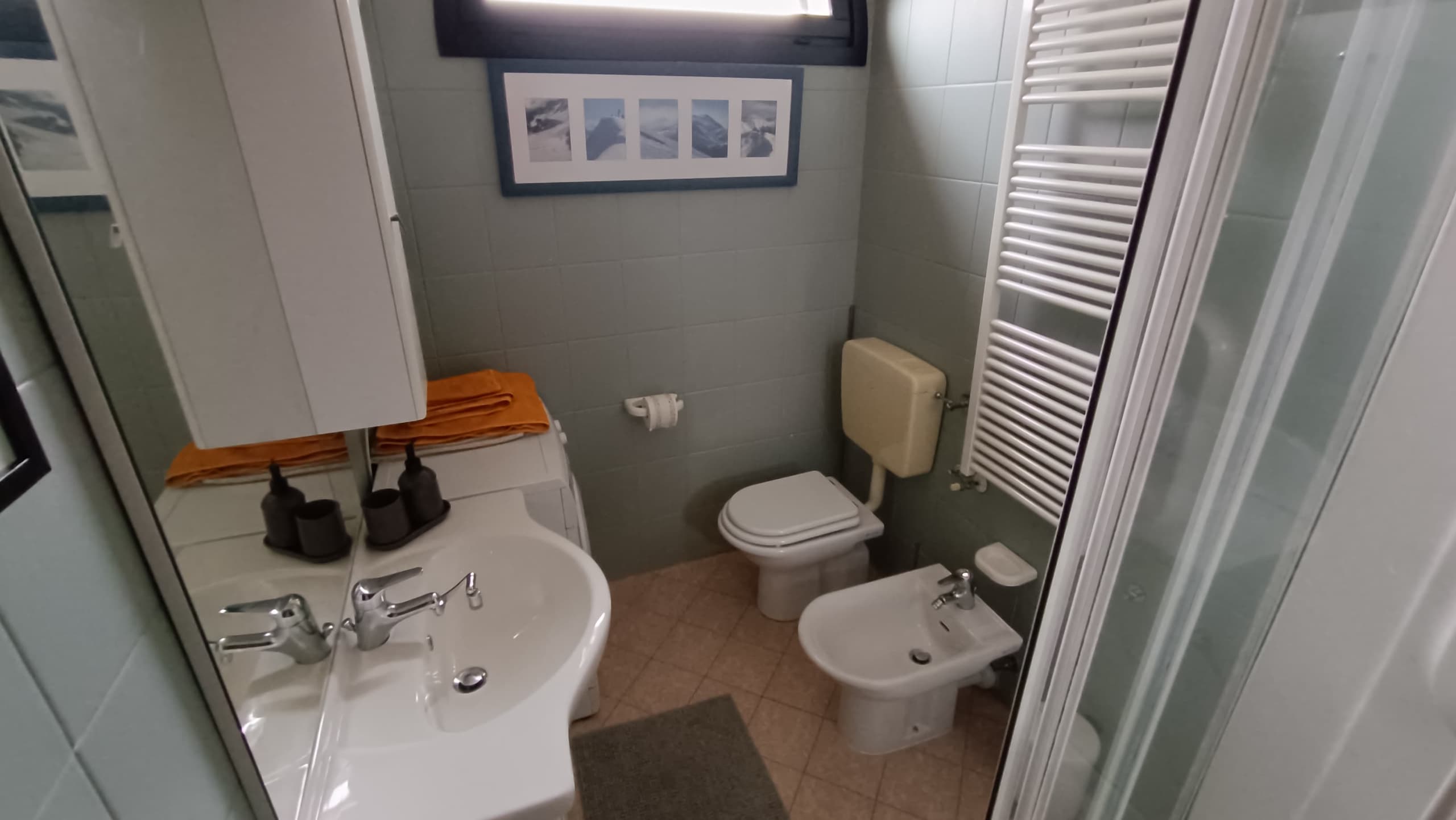 Bagno con lavabo, specchio contenitore, wc, bidet, termoarredo e lavatrice