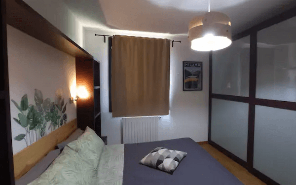 Camera matrimoniale con testiera in legno e armadio a specchio