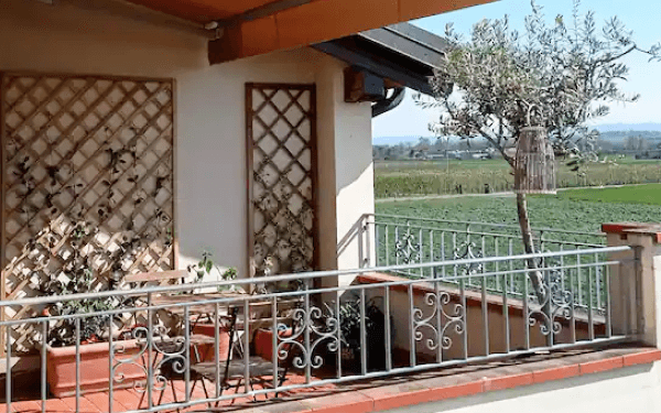 Terrazzo coperto con piante e vista sui campi coltivati